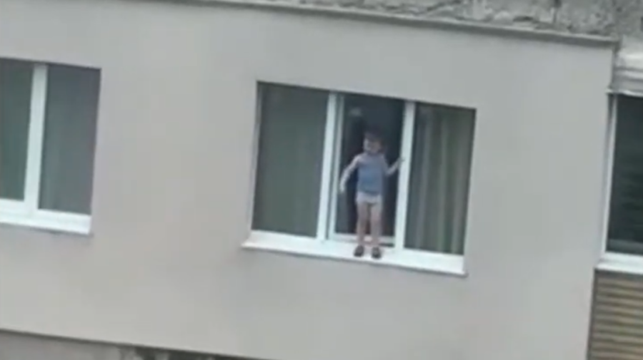 VIDEO Moment de SPAIMĂ! Un copil de patru ani se plimbă pe pervazul unui geam de la etajul nouă