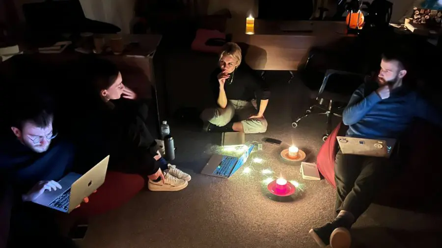 FOTO „Ședințele de lucru devin foarte confortabile”. Jurnaliștii ucraineni lucrează la lumina lumânărilor