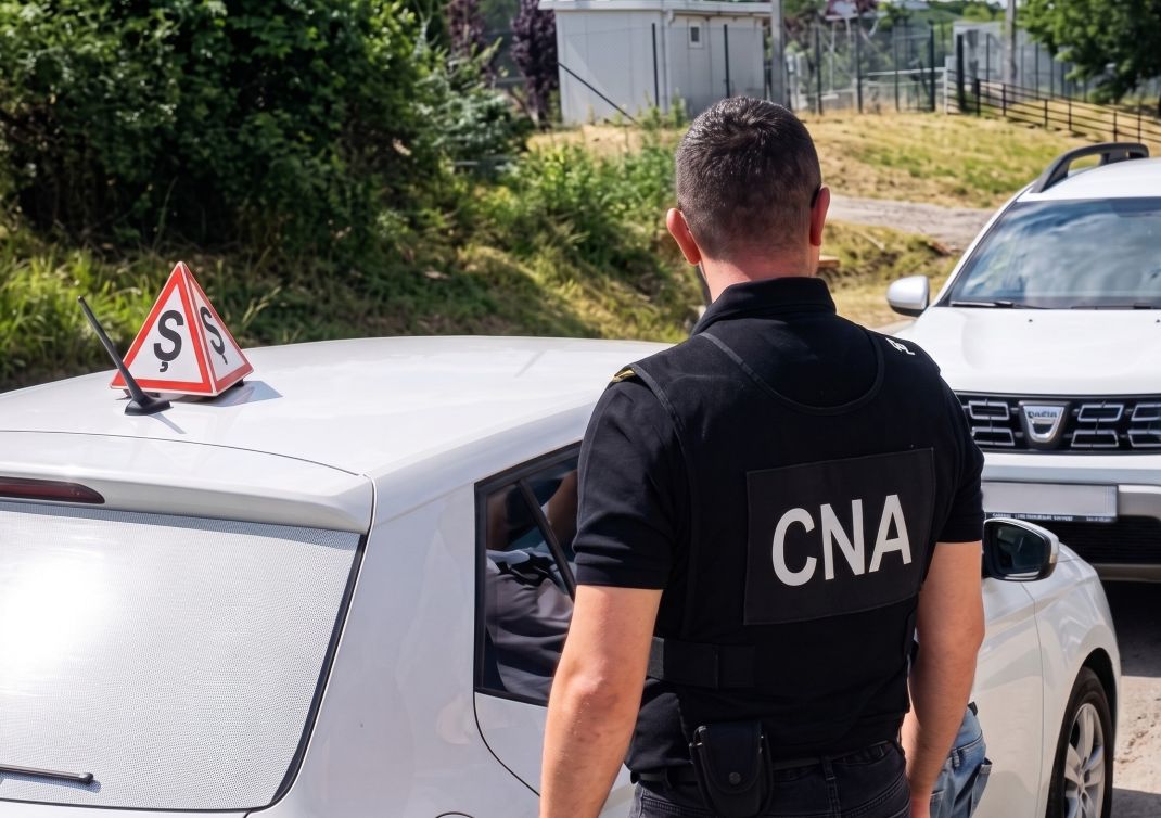 Un instructor auto din Chișinău, încătușat de CNA pentru trafic de influență