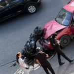 Capota unei mașini, boțită, după impactul cu o motocicletă. Persoana de la ghidon a avut nevoie de ajutor medical